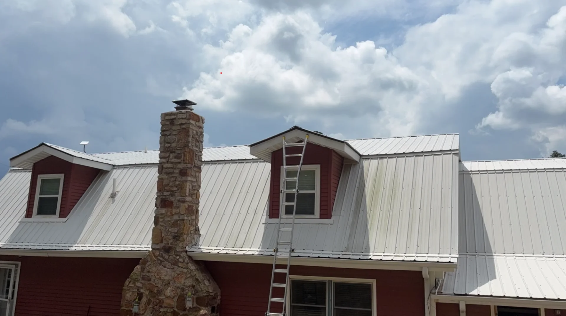 Dormers and metal roof before soft washing on a Mountain View Arkansas home