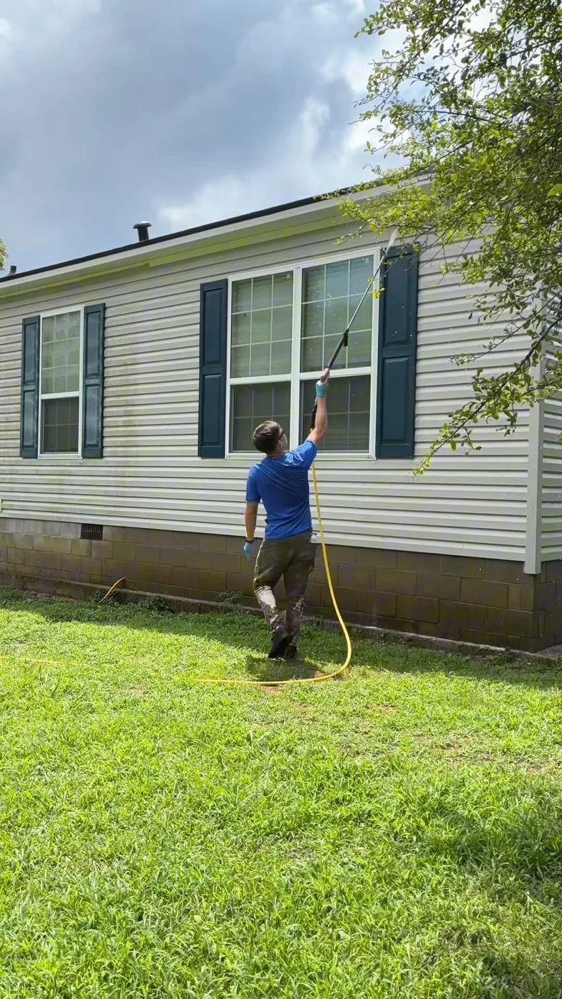Rinsing mobile home vinyl siding during a low pressure soft washing service