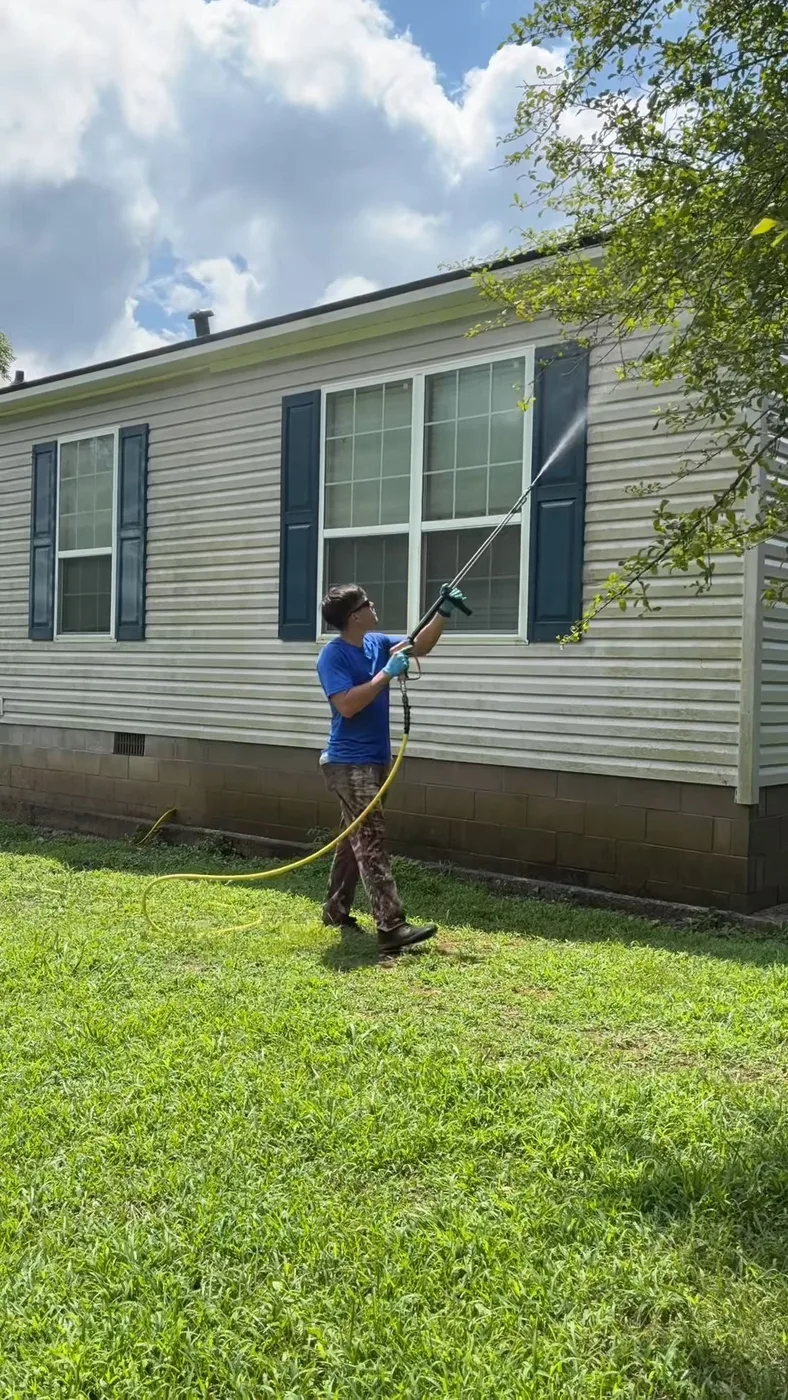 Applying soft wash mix to mobile home vinyl siding from ground level