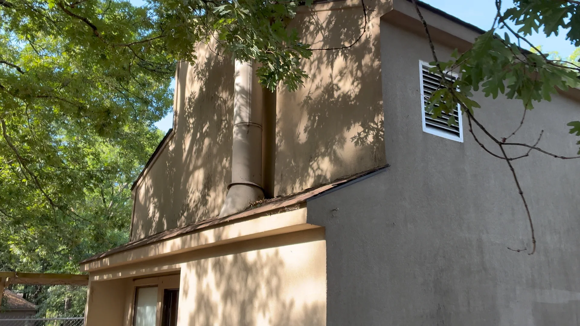 Tall stucco section and chimney chase on a Fairfield Bay Arkansas home before soft washing