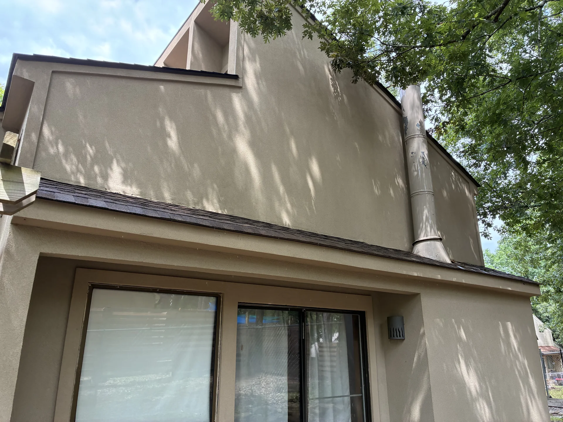 Tall stucco section and chimney chase on a Fairfield Bay Arkansas home after soft washing